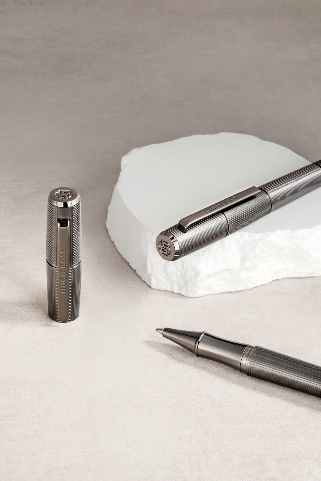 A cordless lamp and a writing instrument on white stone — Hugo Boss